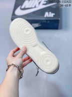 Close-up of the white outsole showing concentric circular traction grooves, with the branded shoebox in the background.