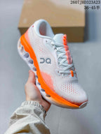 Angled side view of the sneaker showing the white upper, orange outsole, perforations, and On branding.