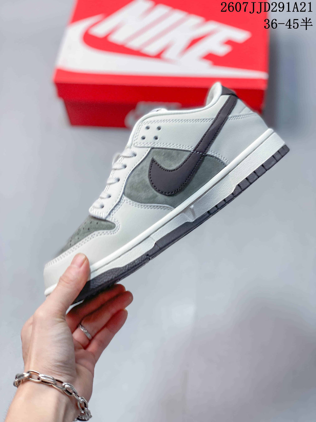 Side profile showing the white and grey upper, dark side detailing, perforated panels, white midsole, and dark outsole.