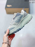 Side profile of the gray low-top sneaker showing its layered upper, pale green midsole and dark outsole.