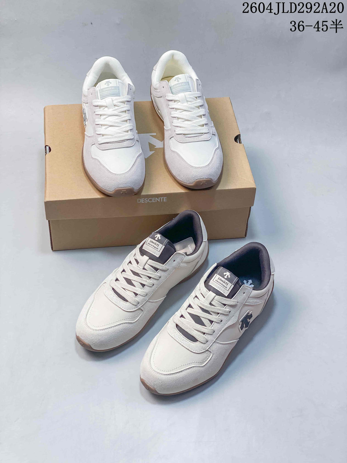Several views of off-white DESCENTE low-top sneakers with contrasting dark tongue and collar accents, shown with a branded box; image overlay shows style code 2604JLD292A20 and sizes 36–45.5.