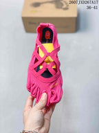 Top view of a pink five-finger shoe showing the separate toe sections, crossover straps, and yellow insole.