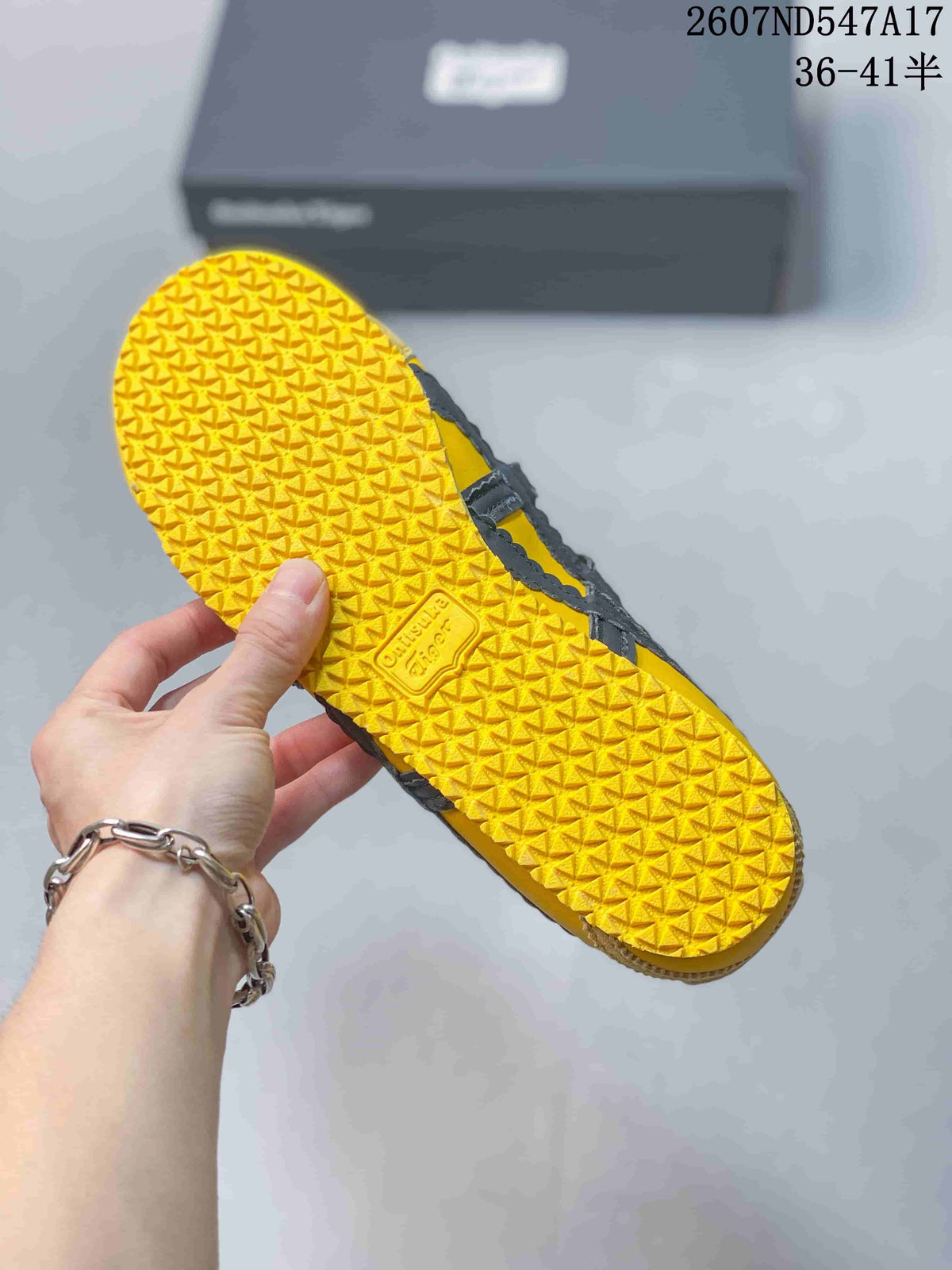 Close view of the yellow textured outsole with repeating tread and Onitsuka Tiger branding.