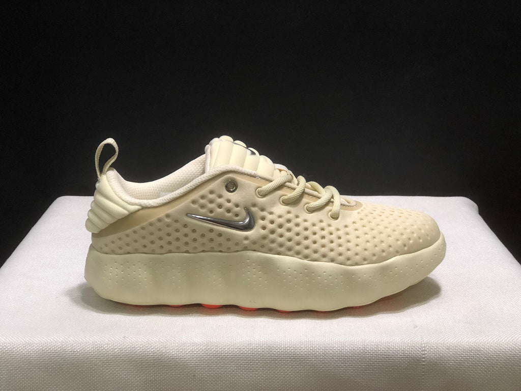 Opposite side profile of a cream Nike Mind 002 sneaker showing the lace-up design, padded collar, and silver branding.