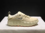 Opposite side profile of a cream Nike Mind 002 sneaker showing the lace-up design, padded collar, and silver branding.