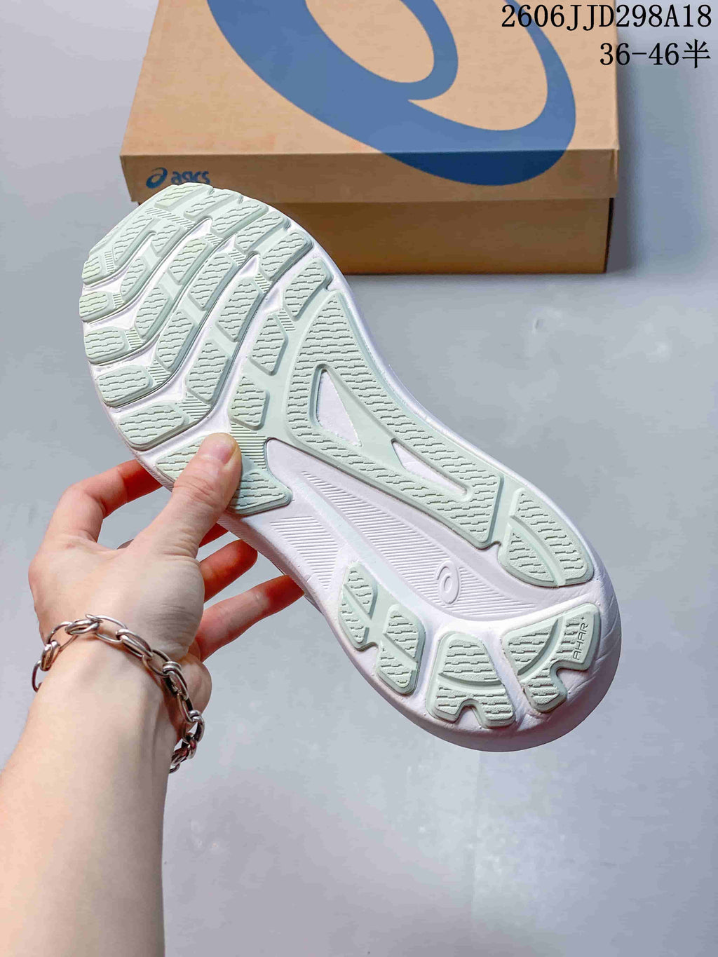 Close view of the ASICS running shoe outsole showing segmented traction sections and grooves.