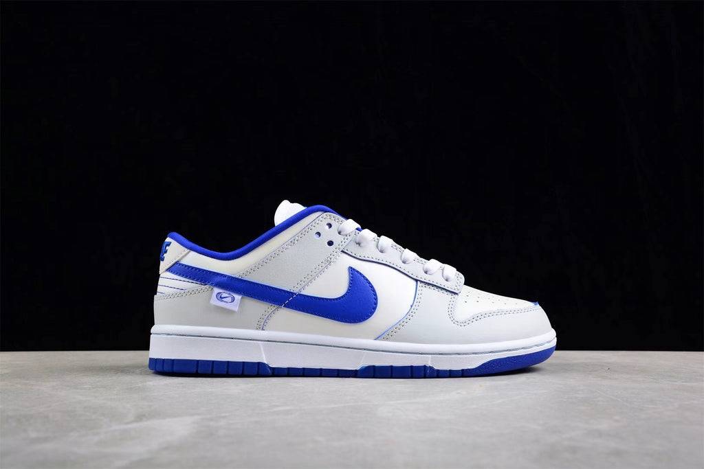 Side profile highlighting the white upper, blue side branding, blue collar, and layered panels.