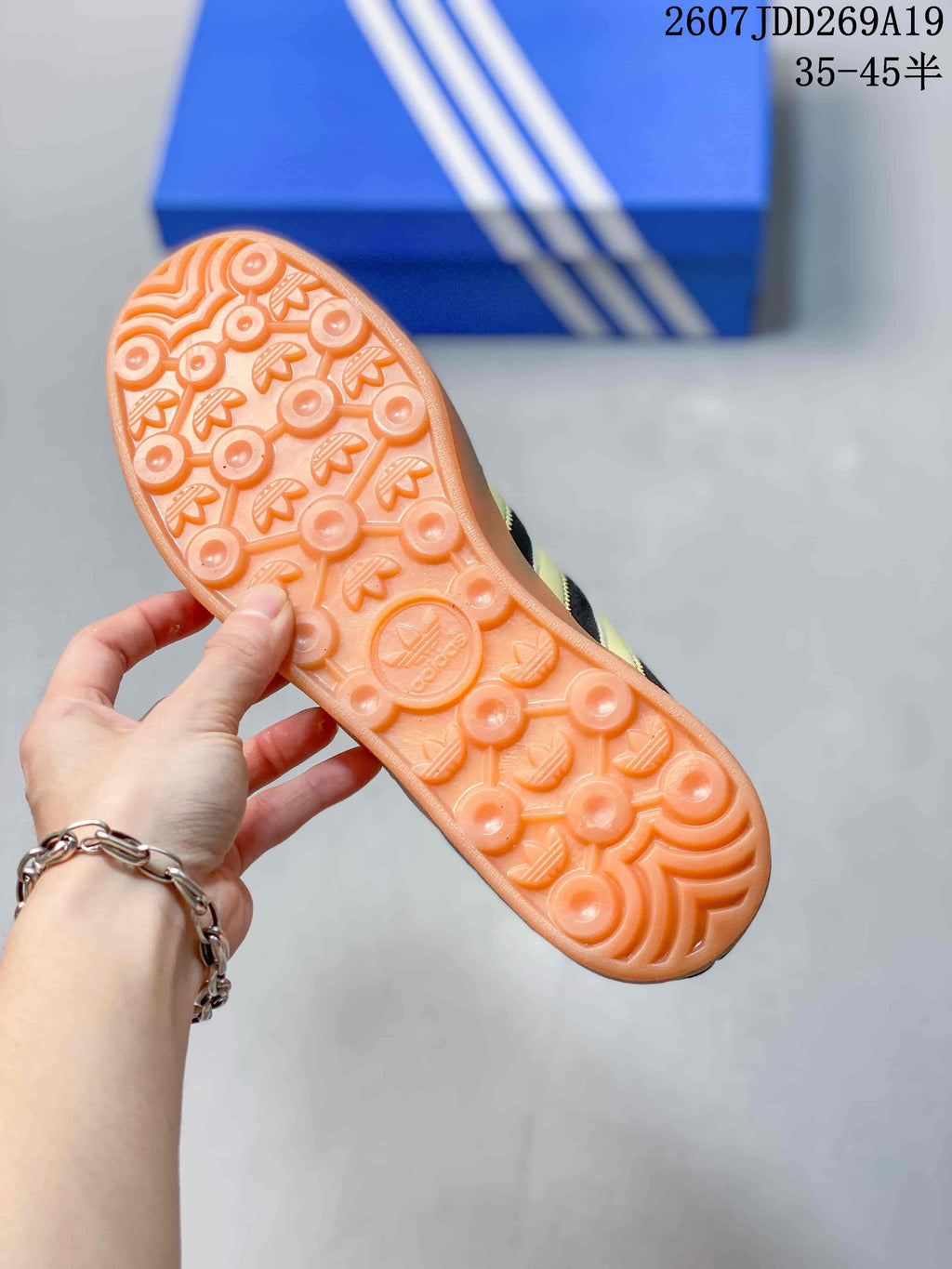 Close view of the gum-colored outsole showing circular and trefoil-pattern tread.