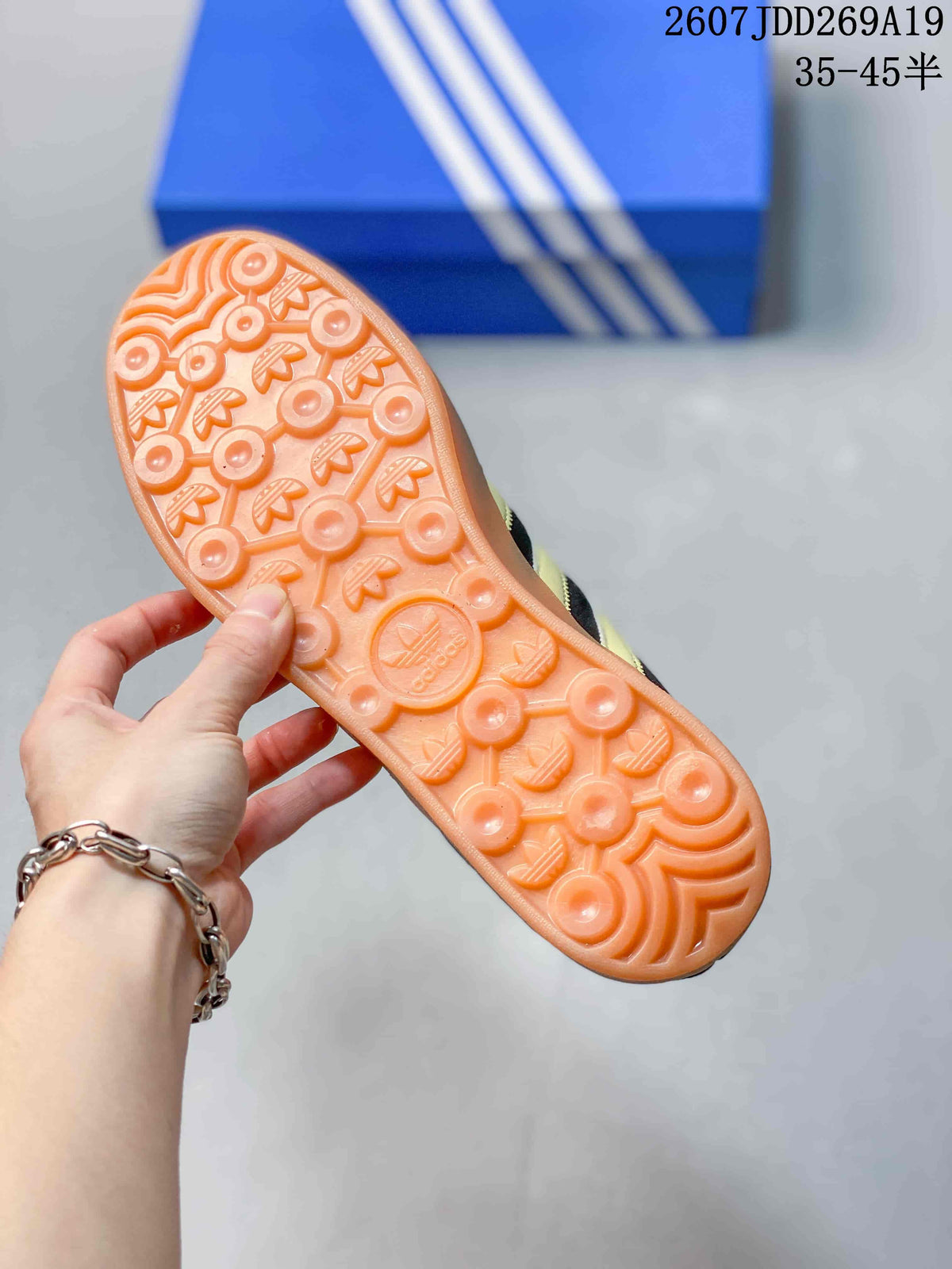 Close view of the gum-colored outsole showing circular and trefoil-pattern tread.