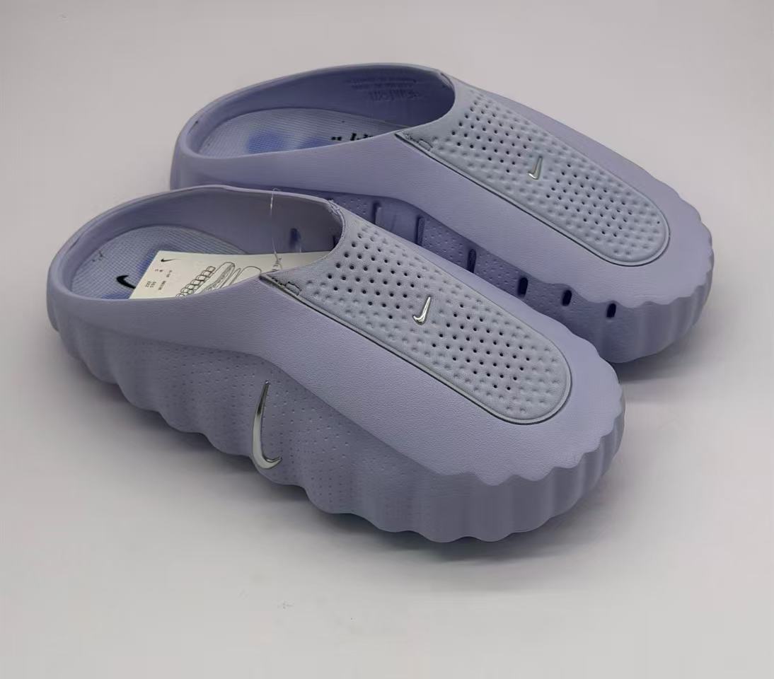 Pair of purple slides shown from above, highlighting the perforated footbeds and upper straps.