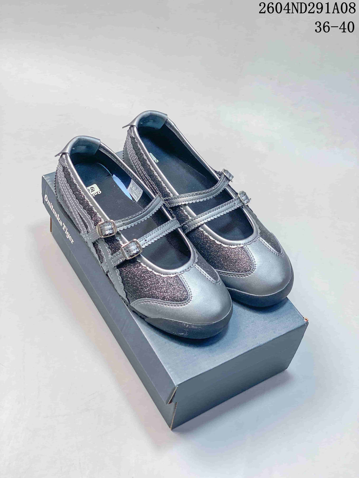 Gray and silver Onitsuka Tiger Mary Jane sneakers displayed on a shoebox, with style code 2604ND291A08 and size range 36-40 visible.