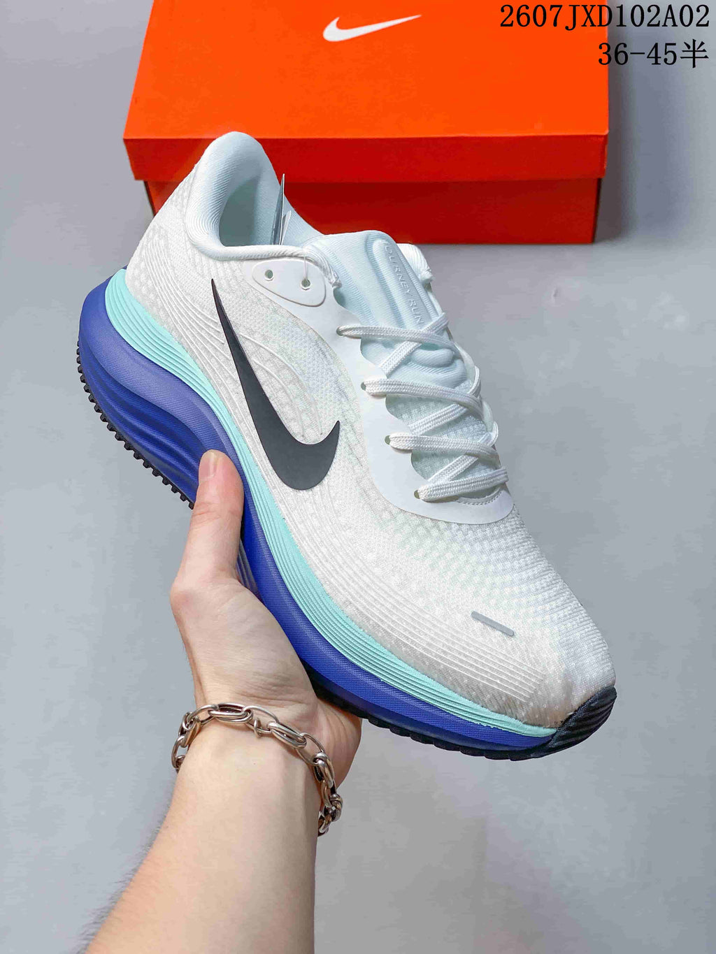 Angled side view of the white running shoe with dark Swoosh and layered-color midsole