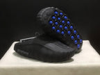 Outsole view showing multiple blue traction pods set into the black sculpted sole.