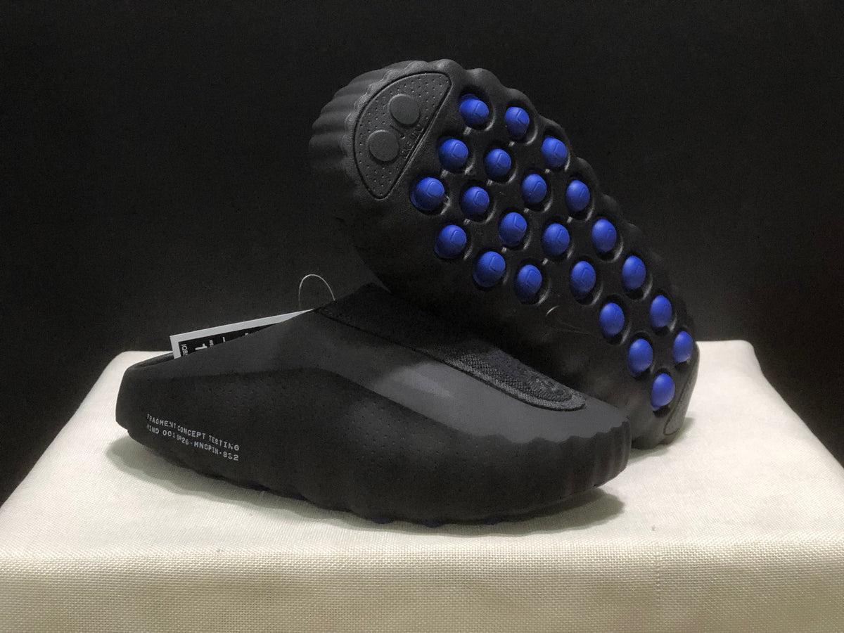 Outsole view showing multiple blue traction pods set into the black sculpted sole.