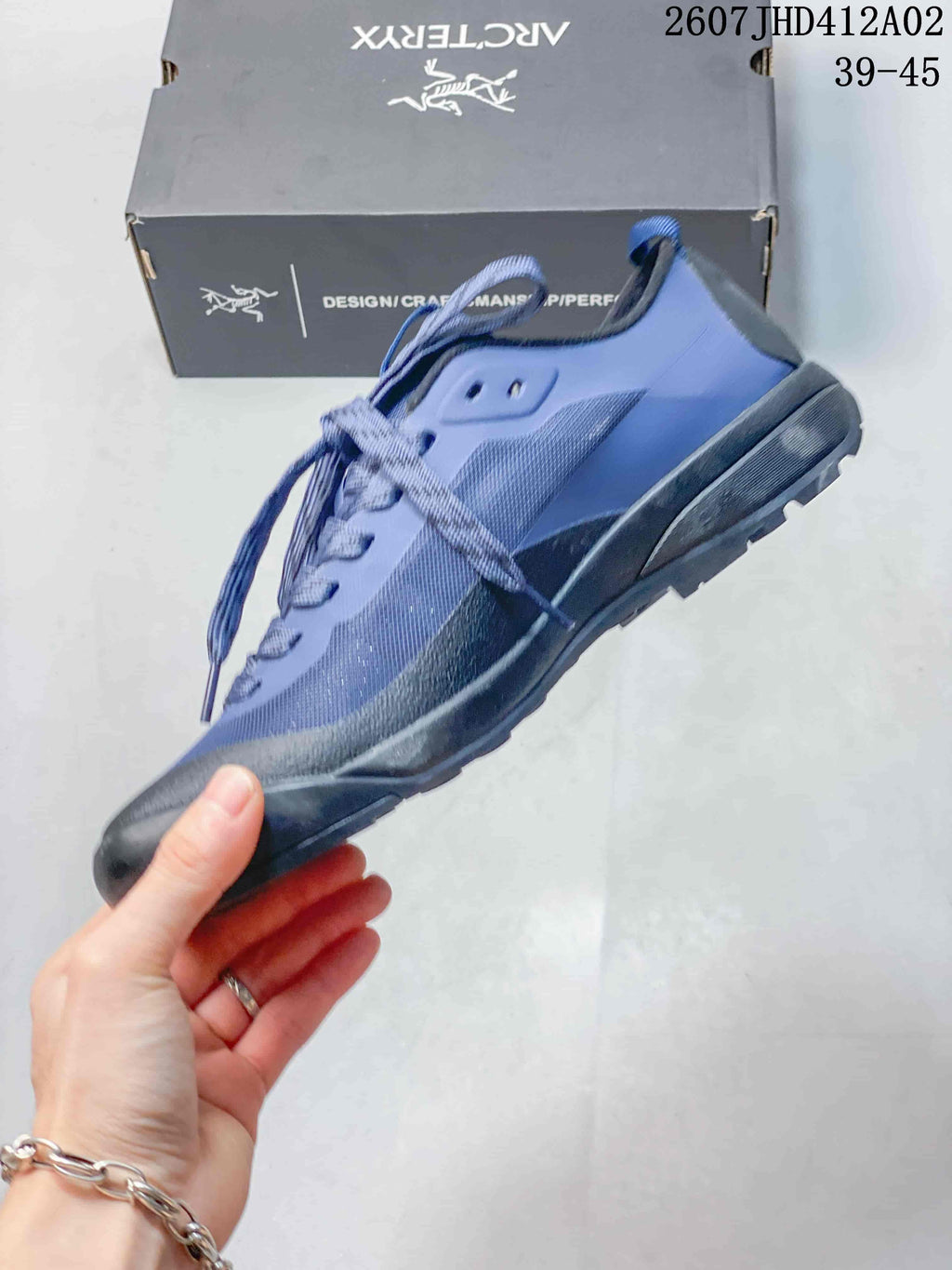 Side view of the blue and dark gray low-cut lace-up shoe
