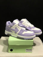 Lavender and white low-top sneakers displayed on a green shoebox, showing the front and side panels.