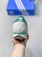 Rear view of the sneaker showing the green adidas trefoil heel tab, white heel panel, and layered sole.