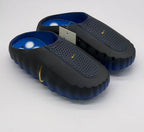 Top angled view of the pair with blue footbeds and perforated black uppers.