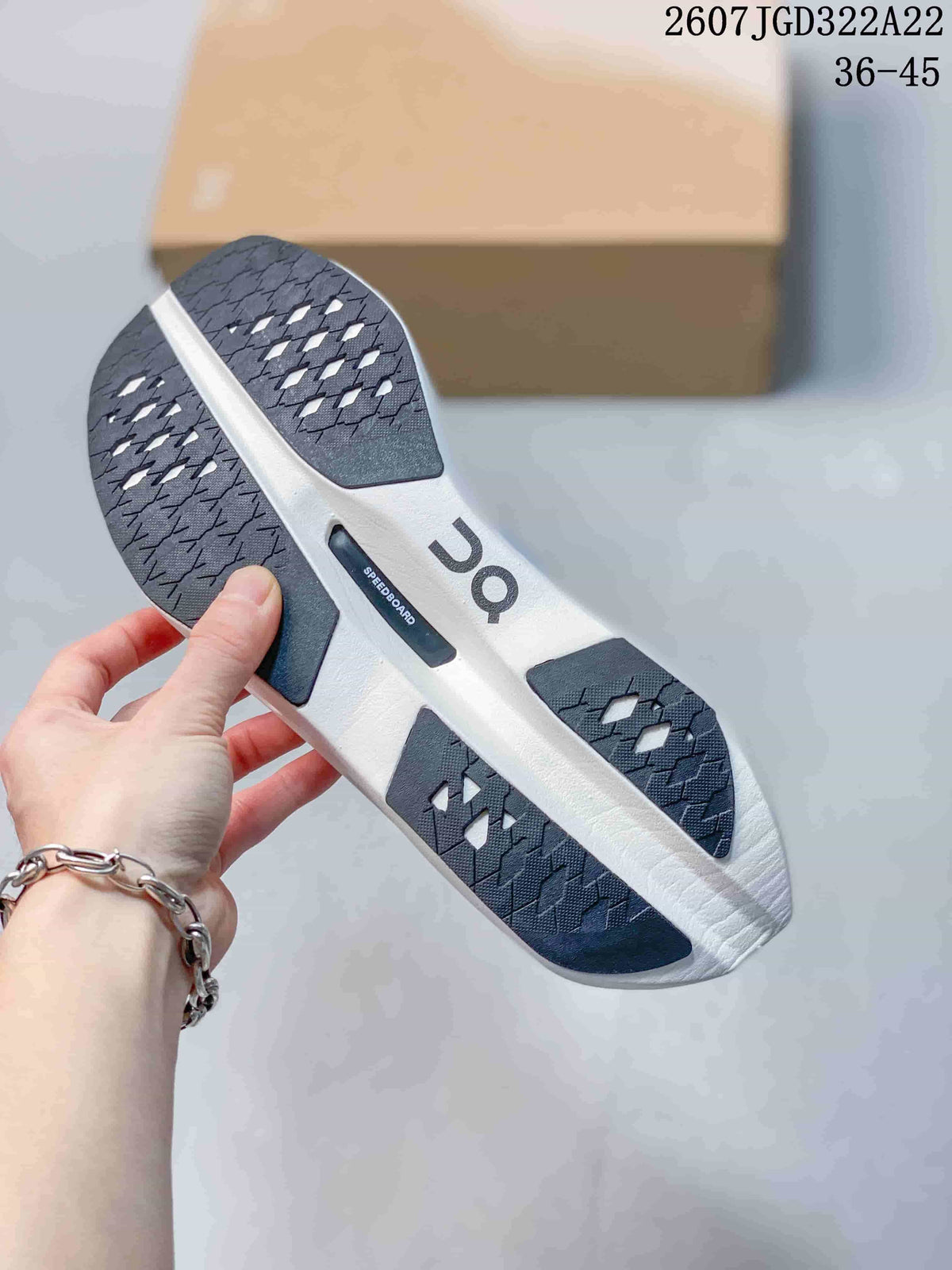 Underside of the shoe showing a segmented black-and-white outsole with textured traction and a visible SPEEDBOARD marking.