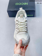 Front view of the white lace-up sneaker with mesh-look panels.
