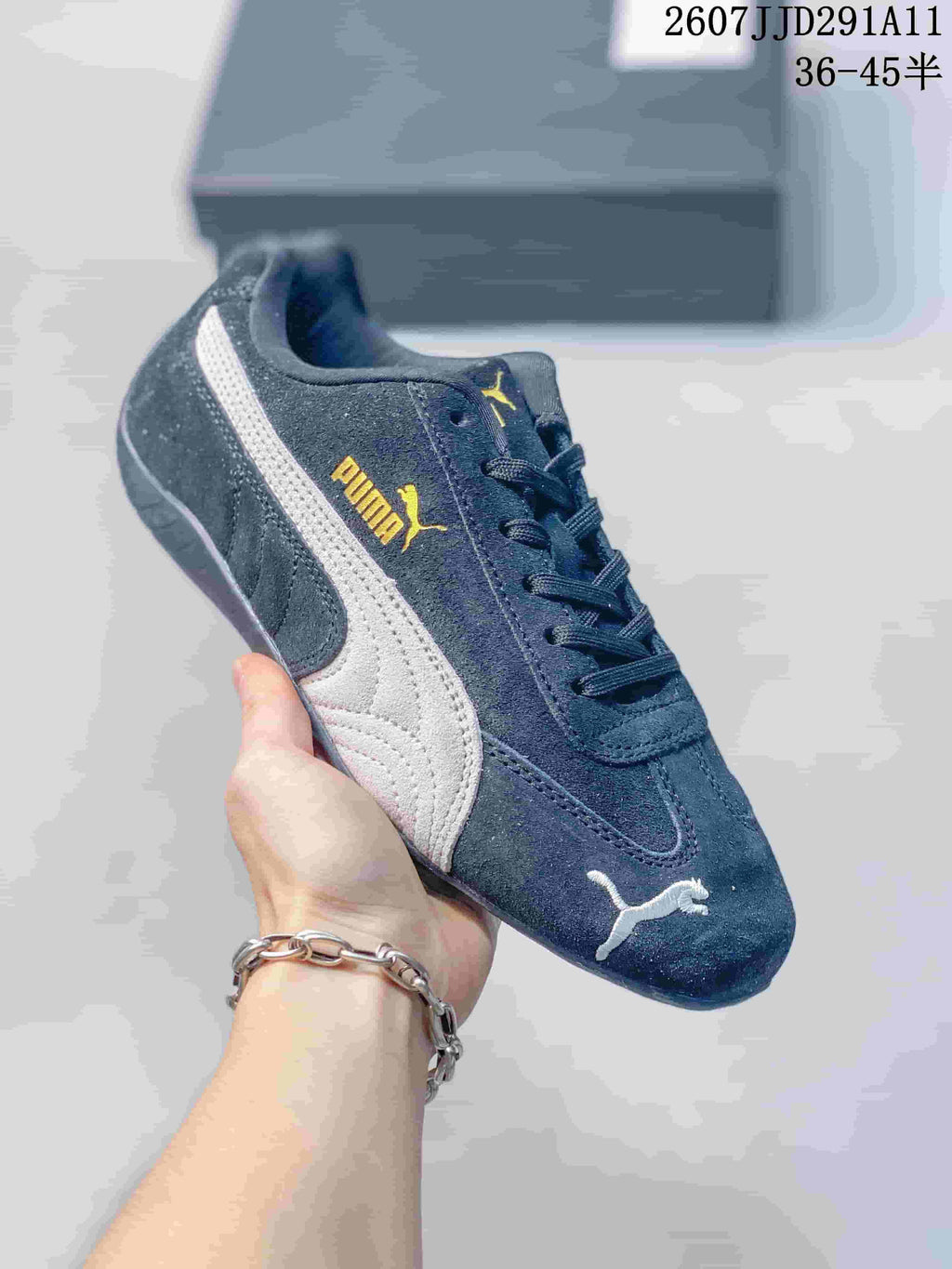 Dark navy PUMA sneaker with a white side stripe, gold branding, and matching dark laces.