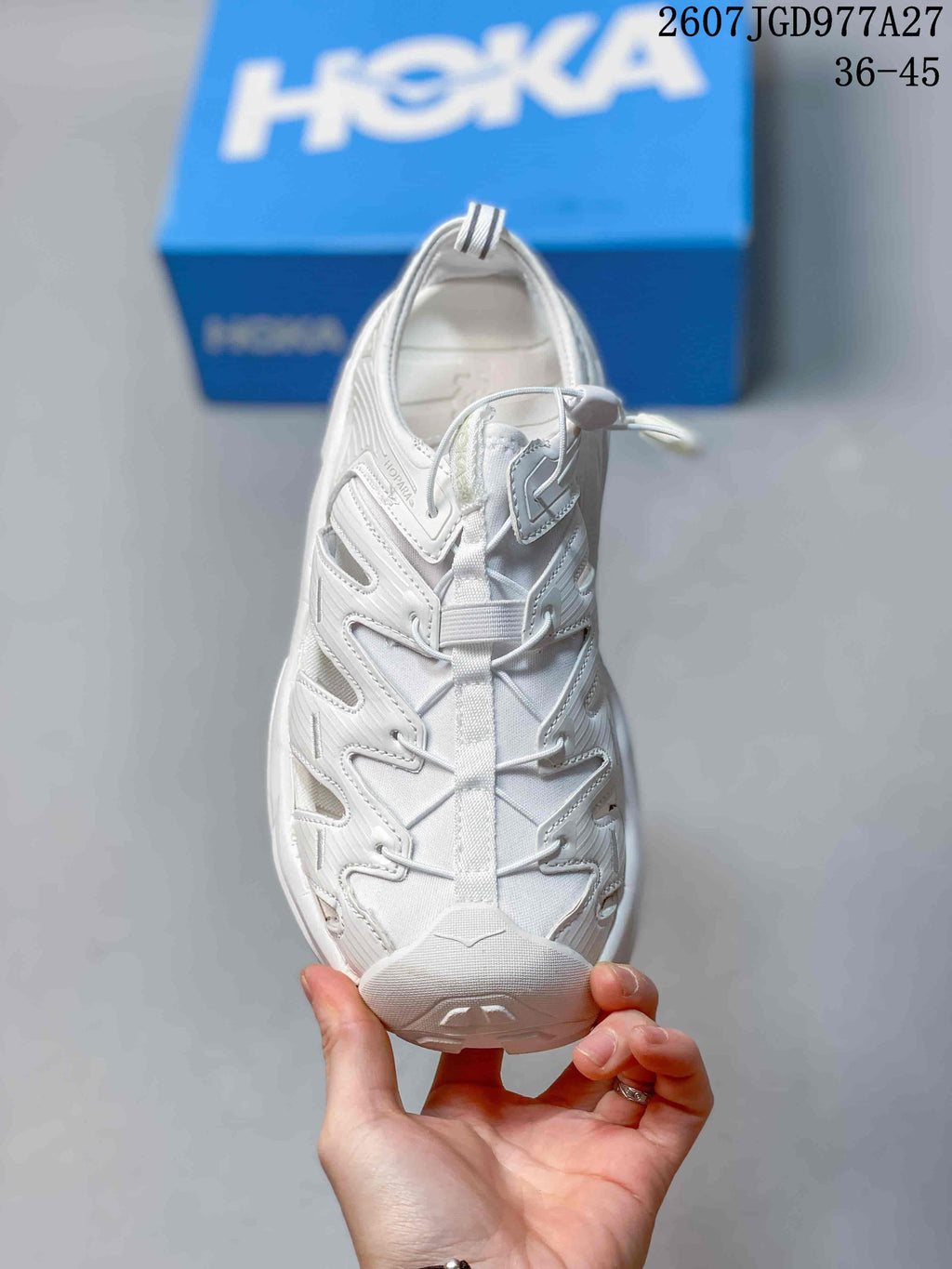 Top view of the white sandal showing the toggle-lacing system and open-sided construction.