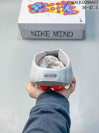 Rear view of the white Nike Mind slide showing the heel badge marked Mind and the orange outsole elements underneath.