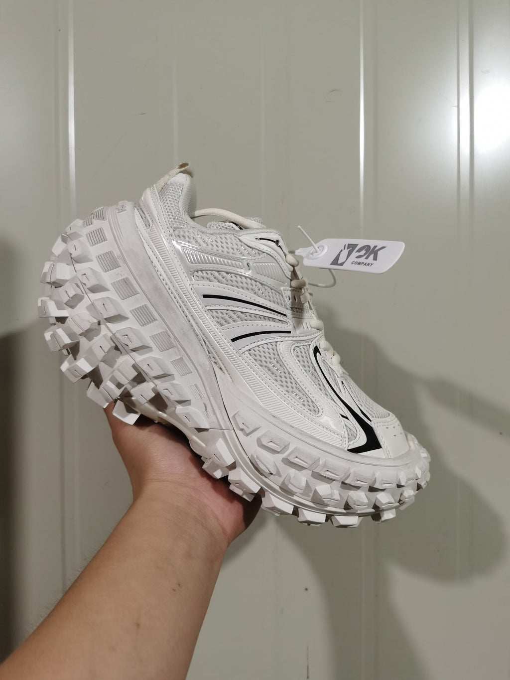 White and black chunky sneaker shown from the outer side, highlighting its layered upper and raised lugged outsole.