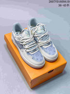 Pair of white and lavender low-top sneakers with Louis Vuitton branding and patterned toe panels on an orange box.