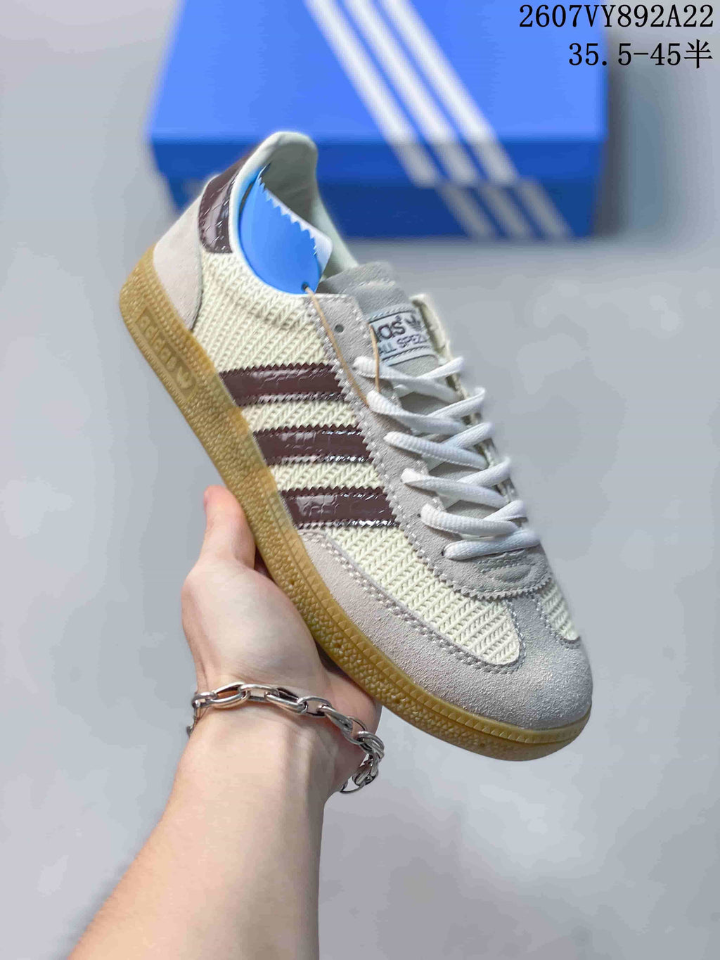 Close side view of a white textured sneaker with dark burgundy stripes, lace-up closure, and gum-colored outsole.
