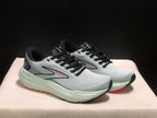 Three-quarter view of the pair highlighting the black laces, gray side panels, and red outsole accents.
