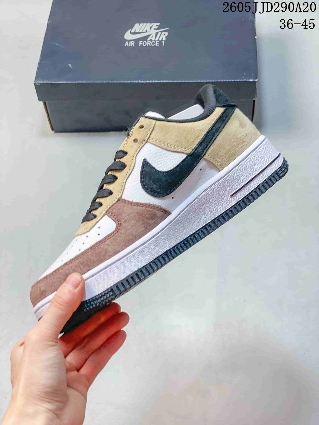 Side view of the sneaker showing layered beige, pink, and white panels, a black Swoosh, and a white midsole.