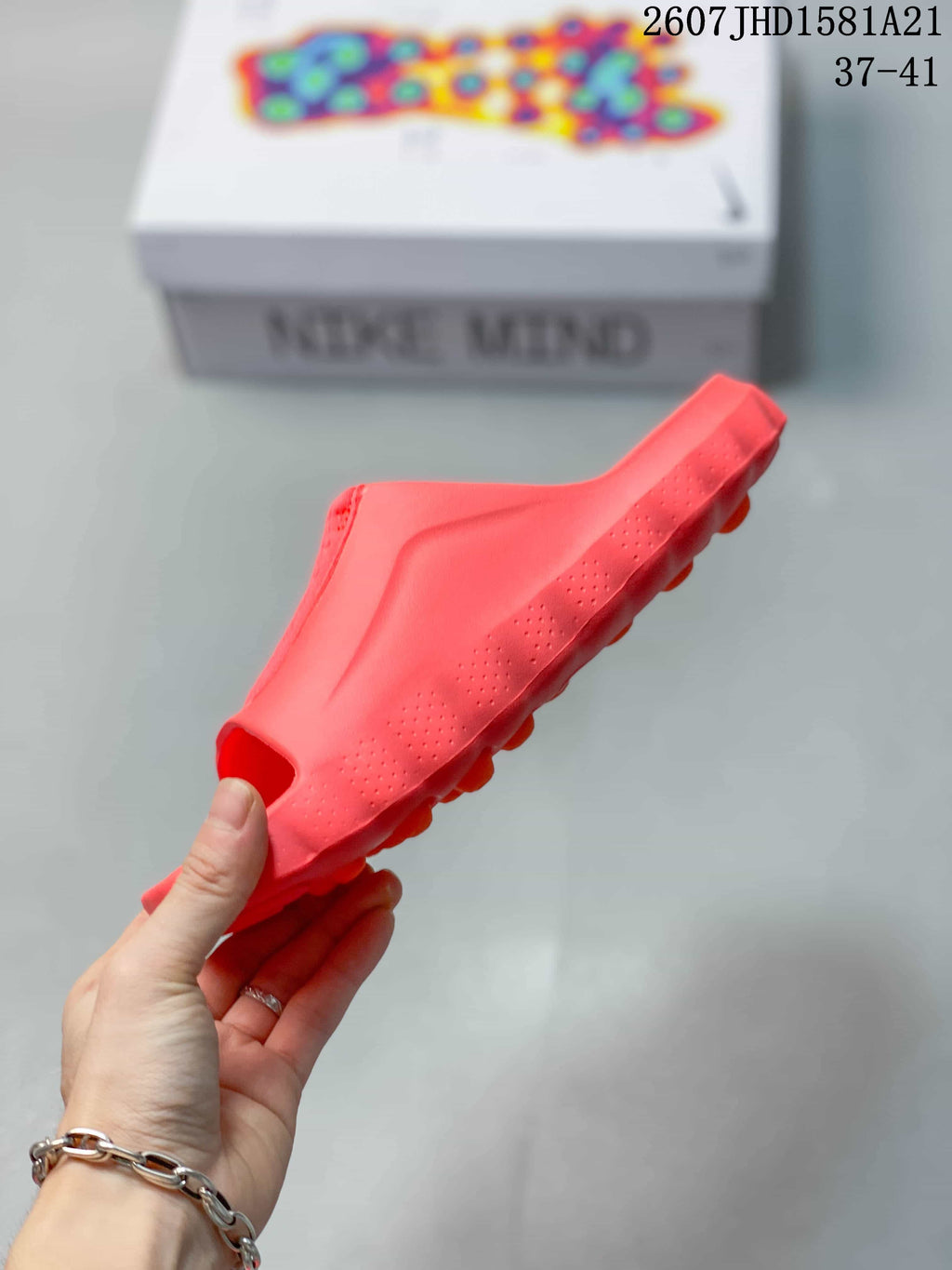 Side profile of the coral mule slide showing the molded sole and textured side details.