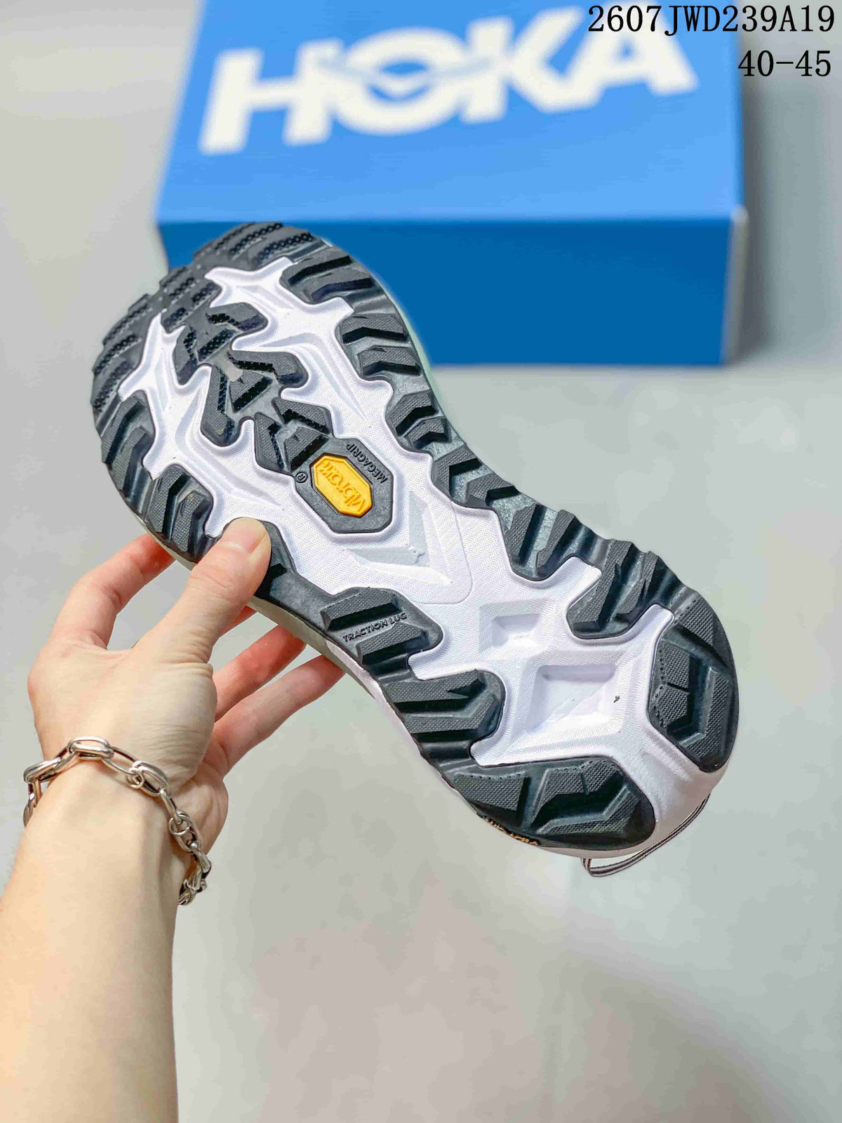 Close view of the shoe outsole showing black and gray tread sections with a yellow Vibram marking.