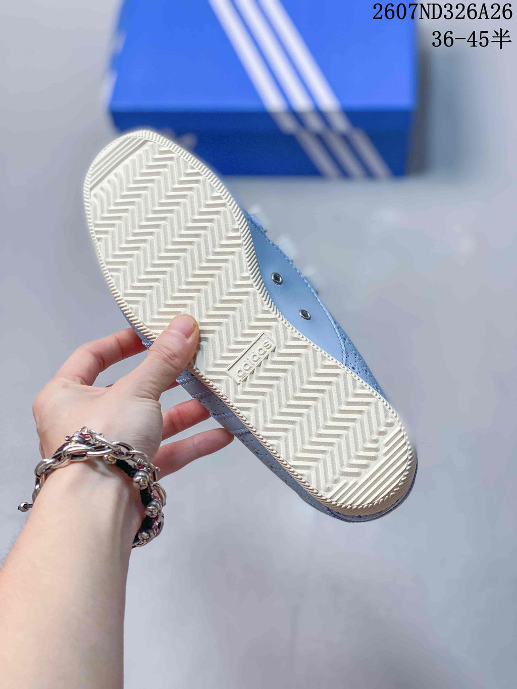 Close view of the cream-colored outsole showing a repeating zigzag tread pattern and an Adidas mark.