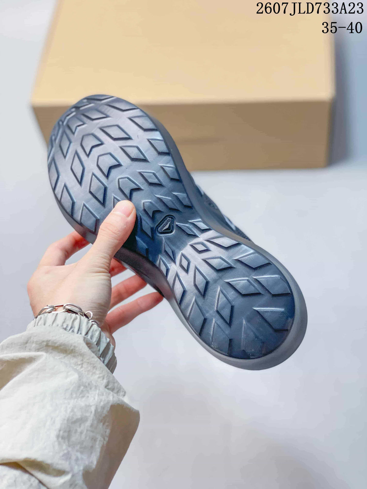 Close view of the Salomon sneaker outsole showing a dark geometric tread pattern and central Salomon mark.