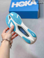 Close view of the sneaker outsole showing blue patterned rubber sections, white sole areas, and a central black insert.