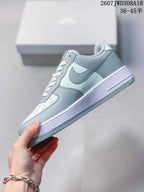 Side profile showing the pale blue upper, contrasting swoosh, layered panels and white midsole.