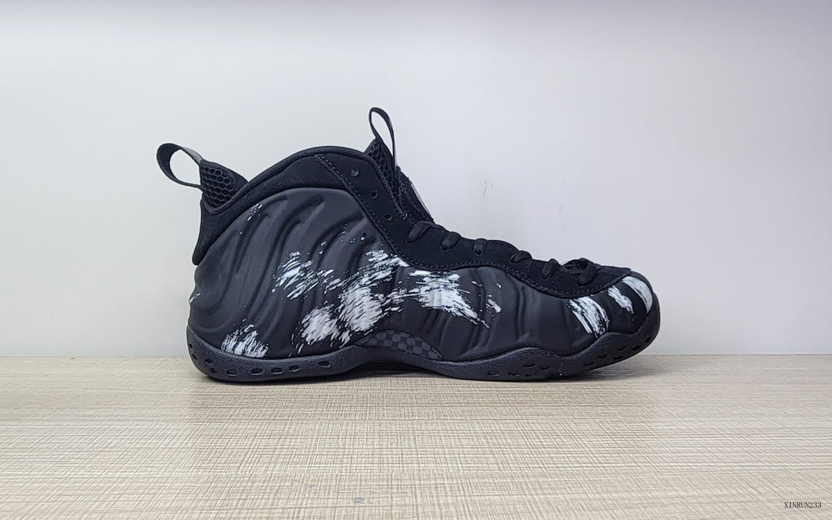 Side profile of a black high-top sneaker with white brushstroke graphics