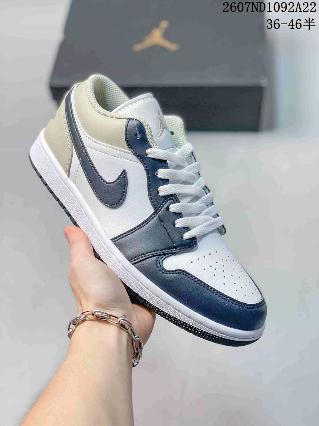 White and dark navy low-top Jordan sneaker with matching navy overlays and Swoosh.