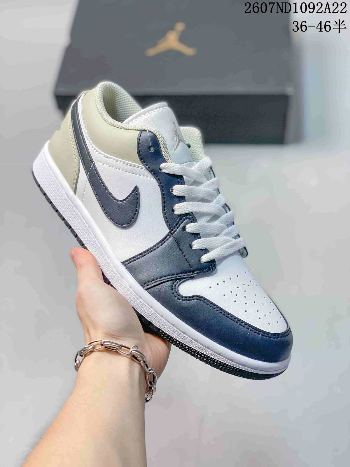 White and dark navy low-top Jordan sneaker with matching navy overlays and Swoosh.