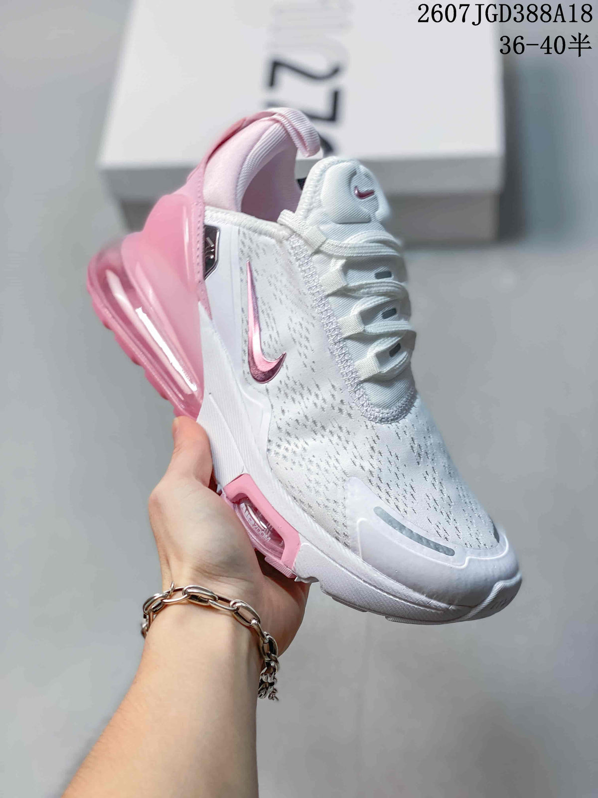 Angled side view of the white and pink Nike Air Max 270 sneaker showing the Swoosh, perforated-looking upper, and translucent pink heel unit.