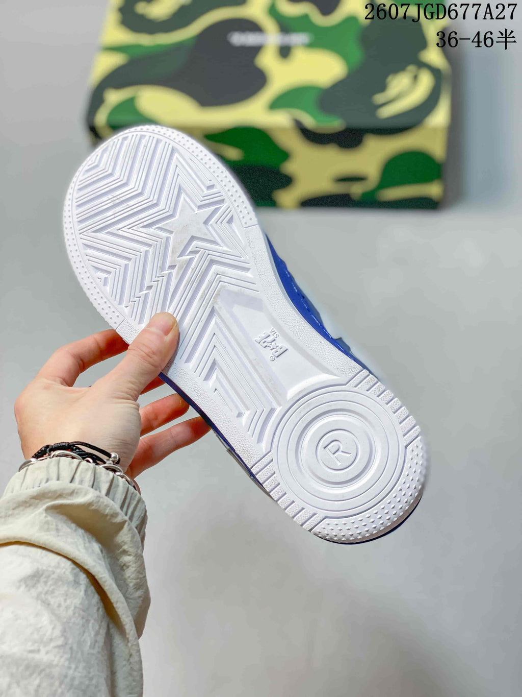 White outsole of a blue and white BAPE STA sneaker, showing star-shaped tread details and circular heel traction.