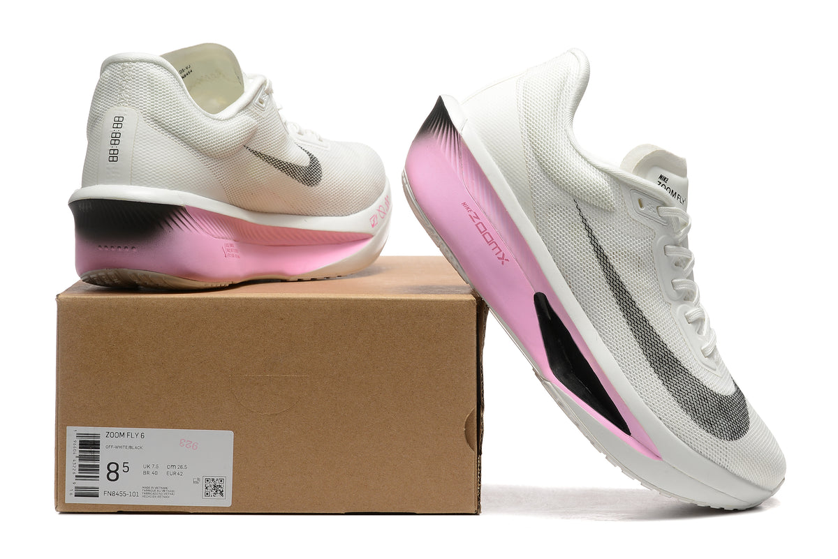 White Nike Zoom Fly 6 shoes with pale pink and black accents beside a box showing a sample size label