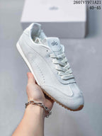 Angled side view of the white Alo sneaker showing the lace-up upper, tonal paneling, and gum-colored outsole.