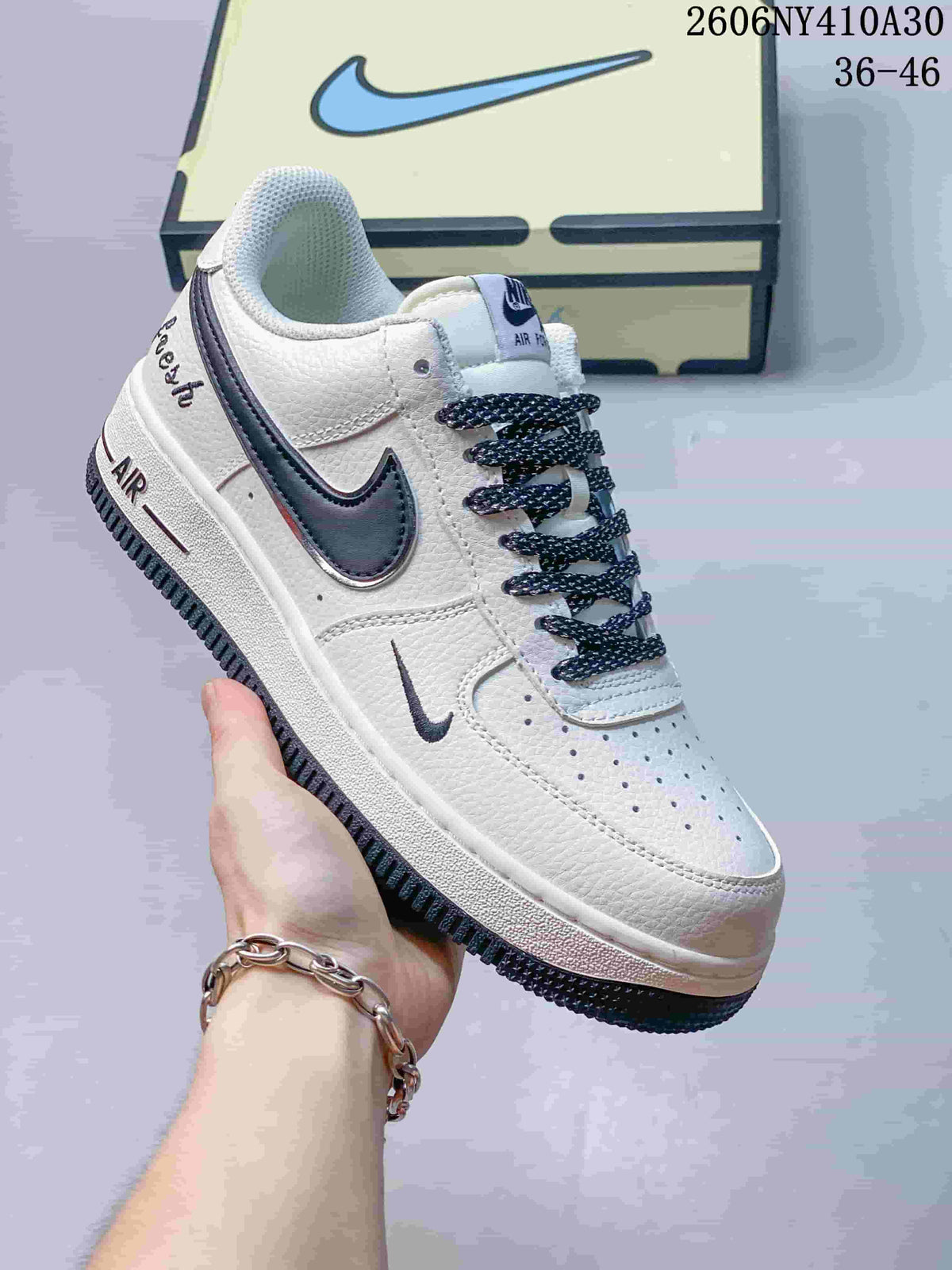 Angled side view of the white Nike Air Force 1 '07 Low with navy details