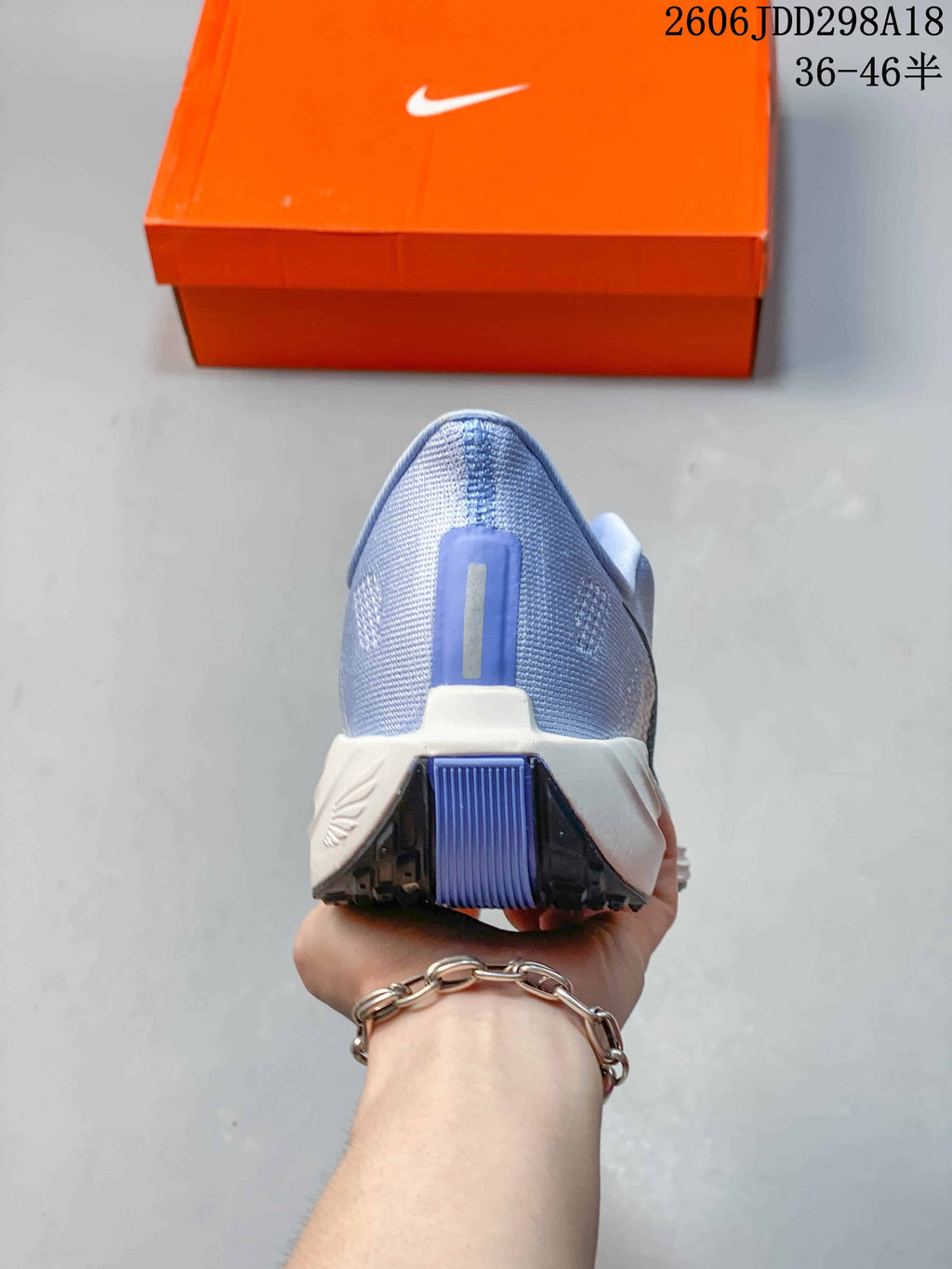 Rear view of the light blue Nike running shoe showing the heel, reflective-looking vertical detail and segmented outsole.