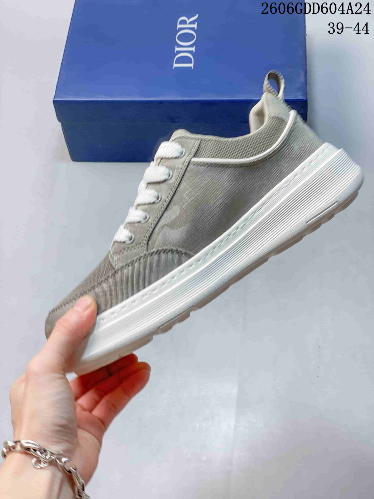 Side profile of a gray-green Dior sneaker with white laces and outsole