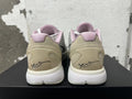 Rear view of white and grey Nike basketball shoes with pale pink collar lining and heel graphics.
