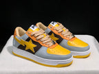 Three-quarter view of the pair highlighting the grey, yellow, black, and orange color blocking.